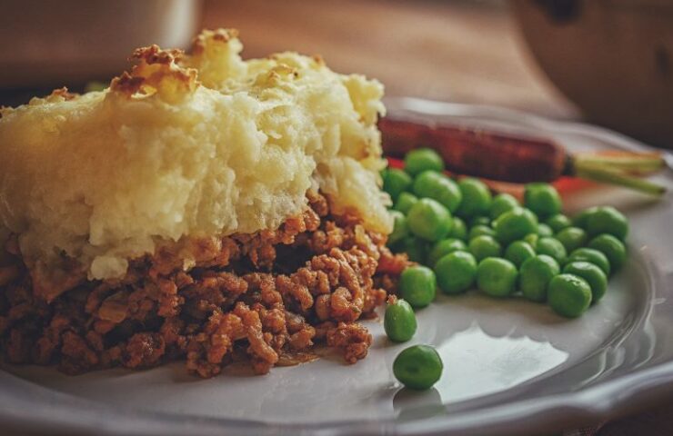 cottage pie on a plate with peas