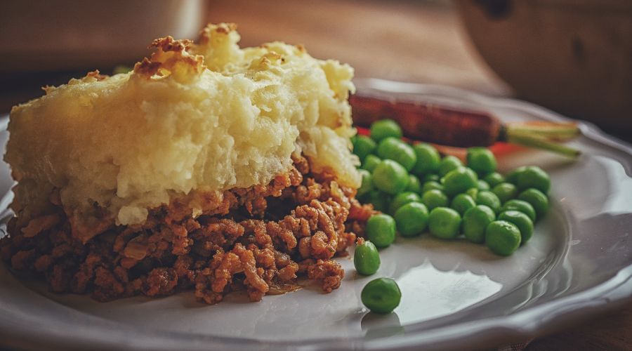 cottage pie on a plate with peas